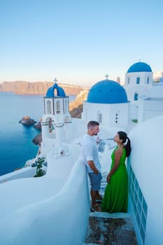 Couple on vacation in Santorini Greece, men and women visit the whitewashed Greek village of Oia during summer vacation on a sunny day