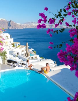 Couple on vacation in Santorini Greece, men, and women relaxing by a swimming pool of a luxury resort during summer vacation