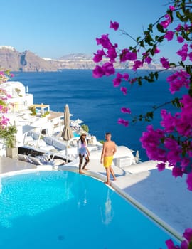 Couple on vacation in Santorini Greece, men, and women relaxing by a swimming pool of a luxury resort during summer vacation
