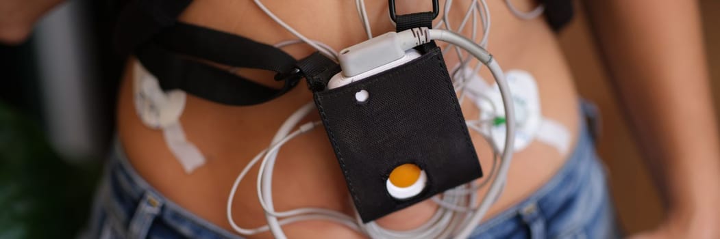 Patient standing with holter electrocardiogram monitor closeup. Diagnosis of arrhythmia and coronary heart disease concept