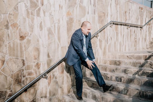 Portrait of a senior professional man in a suit with various problems. A middle-aged businessman with a briefcase descends the stairs.