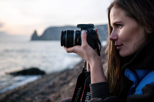 Woman travel sea. Happy tourist taking picture outdoors for memories. Woman traveler looks at the edge of the cliff on the sea bay of mountains, sharing travel adventure journey.