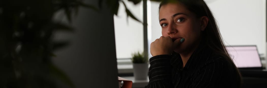 Portrait of tired pensive manager in dark office workplace. Businesswoman working late at headquarters