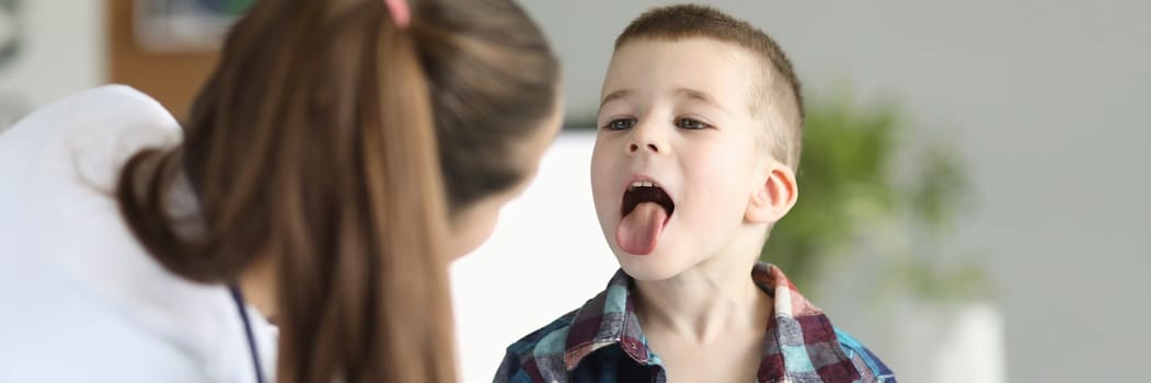 Doctor consults little boy with sore throat. Inflammation of tonsils of adenoids and tonsillitis in children