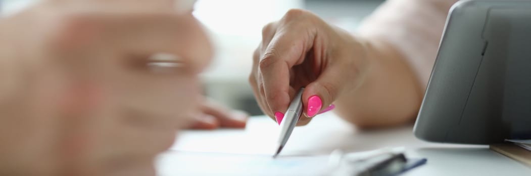 Business people write and discuss documents with tablet computer on table. Signing of insurance documents and contracts