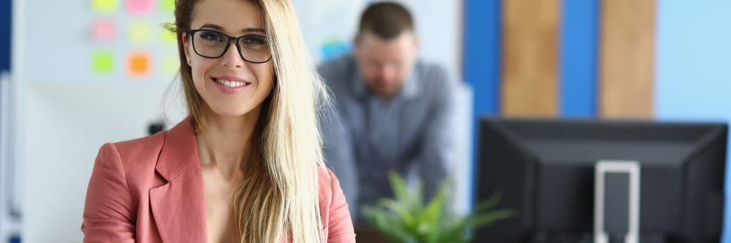 Portrait of smiling business woman in glasses in office. Beautiful business woman working with colleague