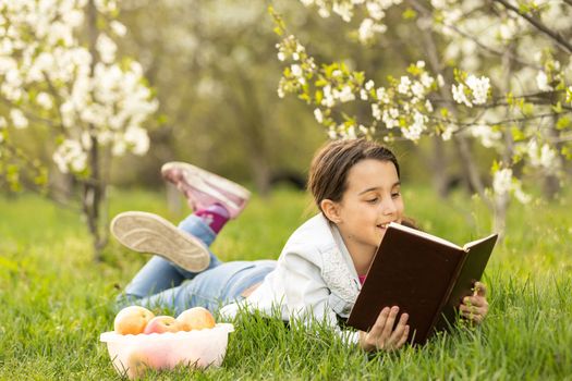 little girl with a bible in the garden.