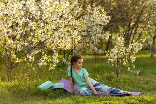 pretty girl doing yoga exercises, little girl doing yoga exercises in the garden