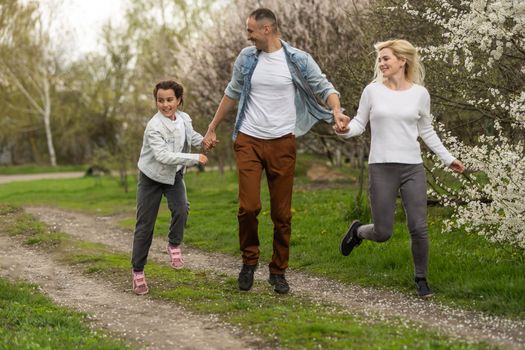 Mother, father and child daughter having fun outdoors.