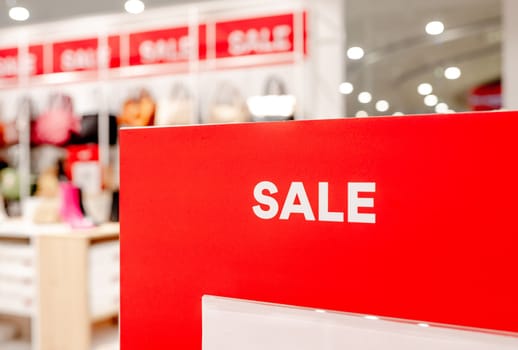 Sale season offers sign in commercial shopping center for better prices and discounts. Business marketing offer and promotions