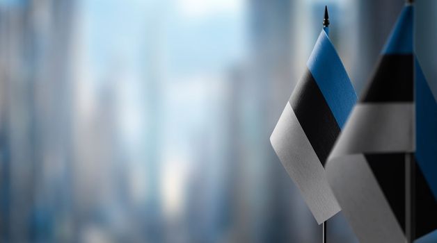 Small flags of the Estonia on an abstract blurry background.