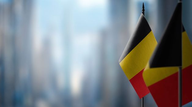 Small flags of the Belgium on an abstract blurry background.