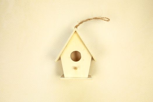 Beautiful bird house on beige background, top view. Space for text Spring concept wooden handmade birdhouse green leafs