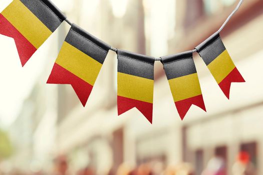 A garland of Belgium national flags on an abstract blurred background.
