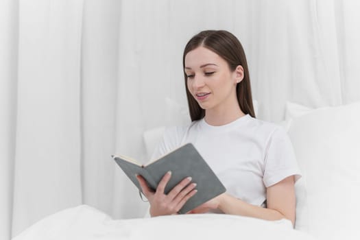 Portrait of Good Healthy woman reading book and resting in bed at bedroom. Lifestyle at home concept