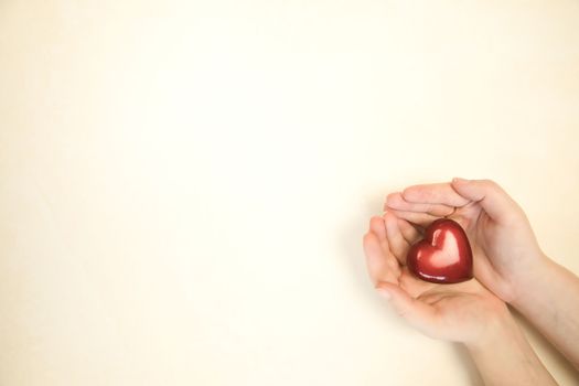 Woman holding red heart in hands on bright color background, top view copy space, Love, romantic, Mother's Day, Valentine's Day soft color Family beauty