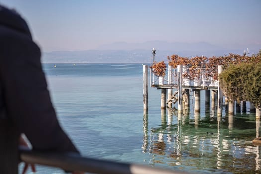 The beautiful landscape of Sirmione on the Garda Lake Riviera, with its crystal clear waters and stunning mountains in the distance.