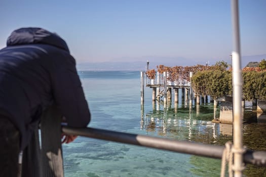 The beautiful landscape of Sirmione on the Garda Lake Riviera, with its crystal clear waters and stunning mountains in the distance.