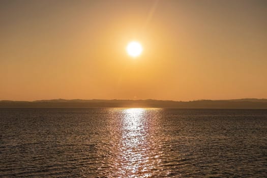 Beautiful sunset over the stunning Garda Lake in Italy, with the sun reflecting on the calm water and creating a peaceful atmosphere. Perfect for travel and nature-related projects.