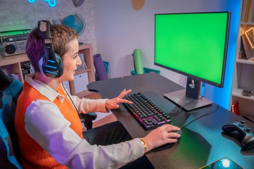Pro gamer girl streaming video games with green screen mockup display in gaming home studio. Player using professional computer wearing headset in neon light room. High quality photo