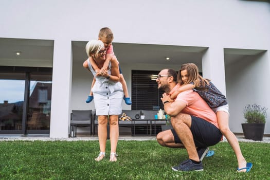 Happy caucasian family of four, mother father and children at home, outdoors playing on the grass, and indoors in the living room having fun as a family.