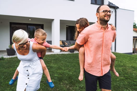 Happy caucasian family of four, mother father and children at home, outdoors playing on the grass, and indoors in the living room having fun as a family.