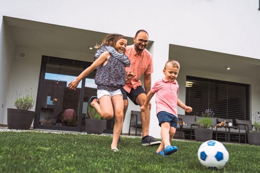 Happy caucasian family of four, mother father and children at home, outdoors playing on the grass, and indoors in the living room having fun as a family.