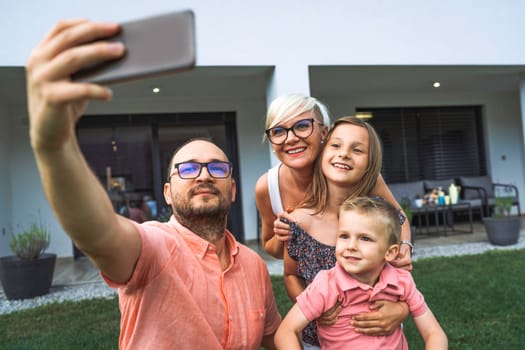 Happy caucasian family of four, mother father and children at home, outdoors playing on the grass, and indoors in the living room having fun as a family.