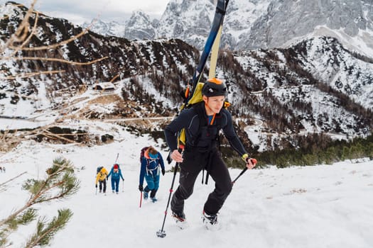 Mountaineer backcountry ski touring in the mountains. Ski touring in high alpine landscape with snowy trees. Adventure winter extreme sport. High quality photo