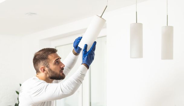 Home Ceiling Light Equipment Maintenance. Professional Electrician Worker