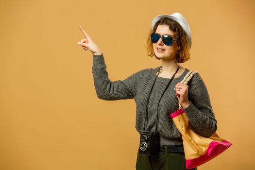 Traveler tourist woman in summer casual clothes, hat with suitcase isolated on yellow orange background. Female passenger traveling abroad to travel on weekends getaway. Air flight journey concept
