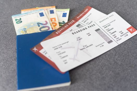 Two tickets for plane with passports on gray background.