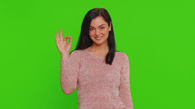 Ok. Joyful happy pretty woman looking approvingly at camera showing approve feedback gesture like sign positive something good. Young girl on green screen chroma key background. People sincere emotion