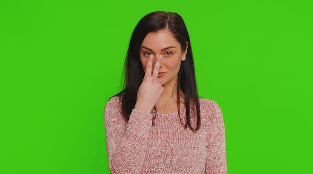 I am watching you. Caucasian woman in sweater pointing at her eyes and camera, show I am watching you gesture, spying on someone. Young adult pretty girl isolated alone on green chroma key background