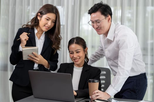 Harmony in office concept as business people analyzing dashboard paper together in workplace. Young colleagues give ideas at manager desk for discussion or strategy planning about project.