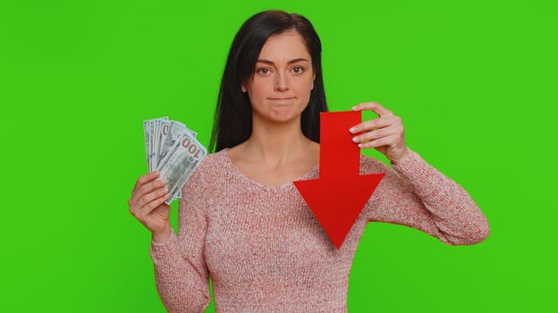 Upset pretty woman showing red arrow pointing down, concept of downgrade, unsuccessful business, fall of stock market money dollar exchange rate bankruptcy fail. Young girl on chroma key background