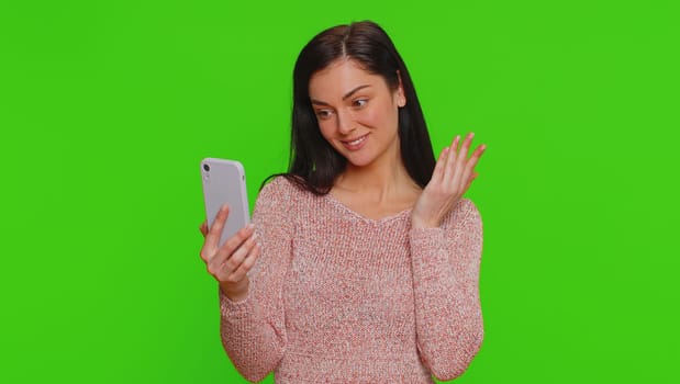 Pretty young woman influencer blogger taking selfie on smartphone, communicating video call online, recording new social media vlog story for subscribers. Girl isolated on chroma key background