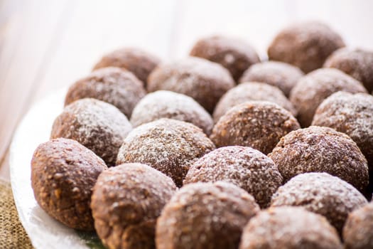 chocolate sweet cakes from mashed biscuits with additives, in a plate on a wooden table.