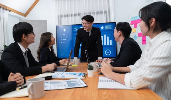 Confidence and asian businessman give presentation on financial analyzed by business intelligence in dashboard report to other people in board room meeting to promote harmony in workplace.