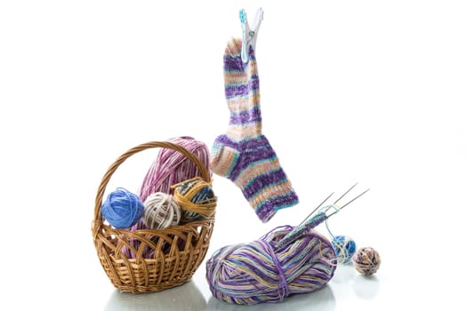 Colored threads, knitting needles and other items for hand knitting, isolated on a white background.