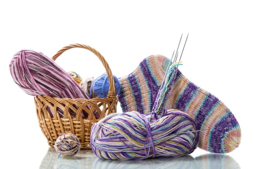 Colored threads, knitting needles and other items for hand knitting, isolated on a white background.