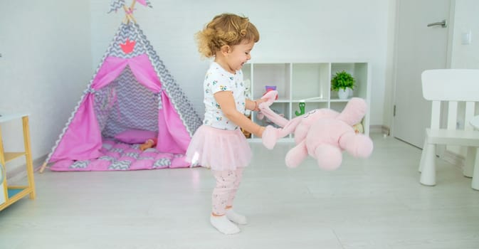 The child plays with toys in the room. Selective focus. Kid.