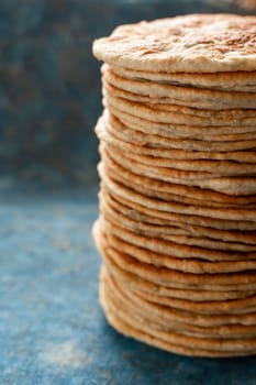 Flatbread lavash, chapati, naan, heap of tortilla on a blue background Homemade flatbread stacked