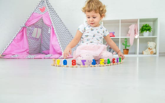 A child plays with a train made of numbers. Selective focus. Kid.