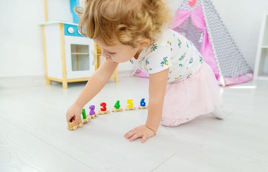A child plays with a train made of numbers. Selective focus. Kid.
