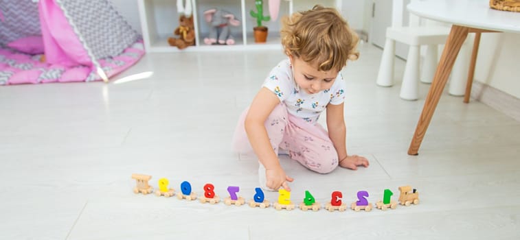 A child plays with a train made of numbers. Selective focus. Kid.