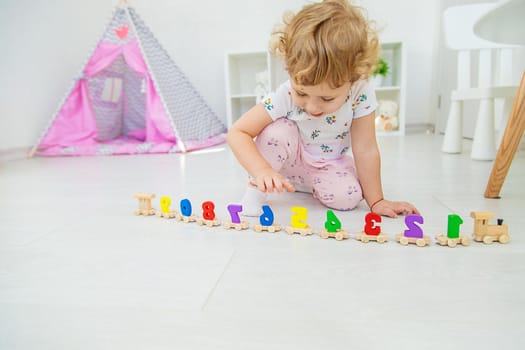 A child plays with a train made of numbers. Selective focus. Kid.