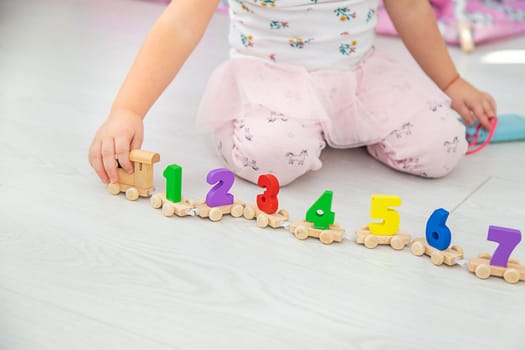 A child plays with a train made of numbers. Selective focus. Kid.