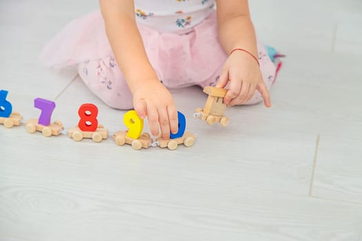 A child plays with a train made of numbers. Selective focus. Kid.