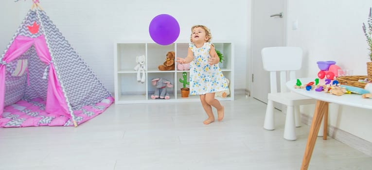 The child is playing with a balloon. Selective focus. Kid.